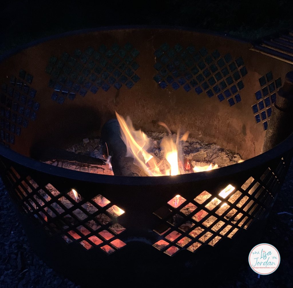 wood burning in a fire pit at night in the summer time