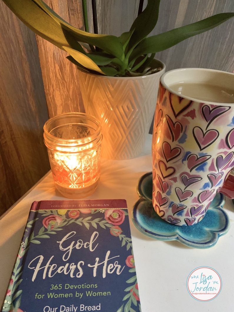 cup of tea with a candle, a plant, and a devotional book titled God Hears Her