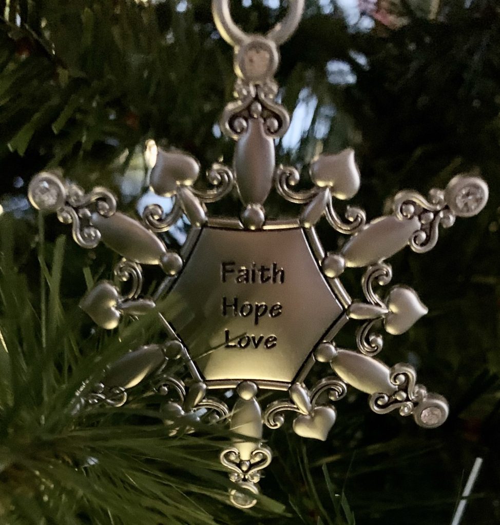 Metal snowflake ornament with faith hope love inscribed in the middle